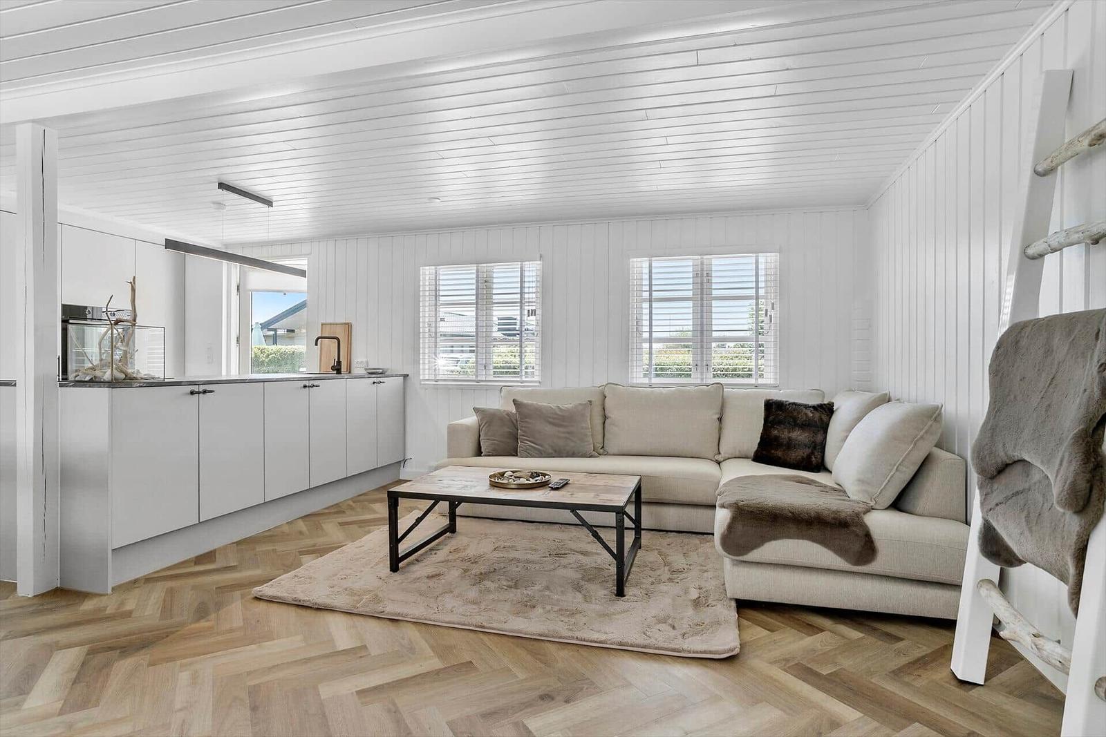 Wohn- und Küchenbereich mit Sofa, Tisch und Holzboden.