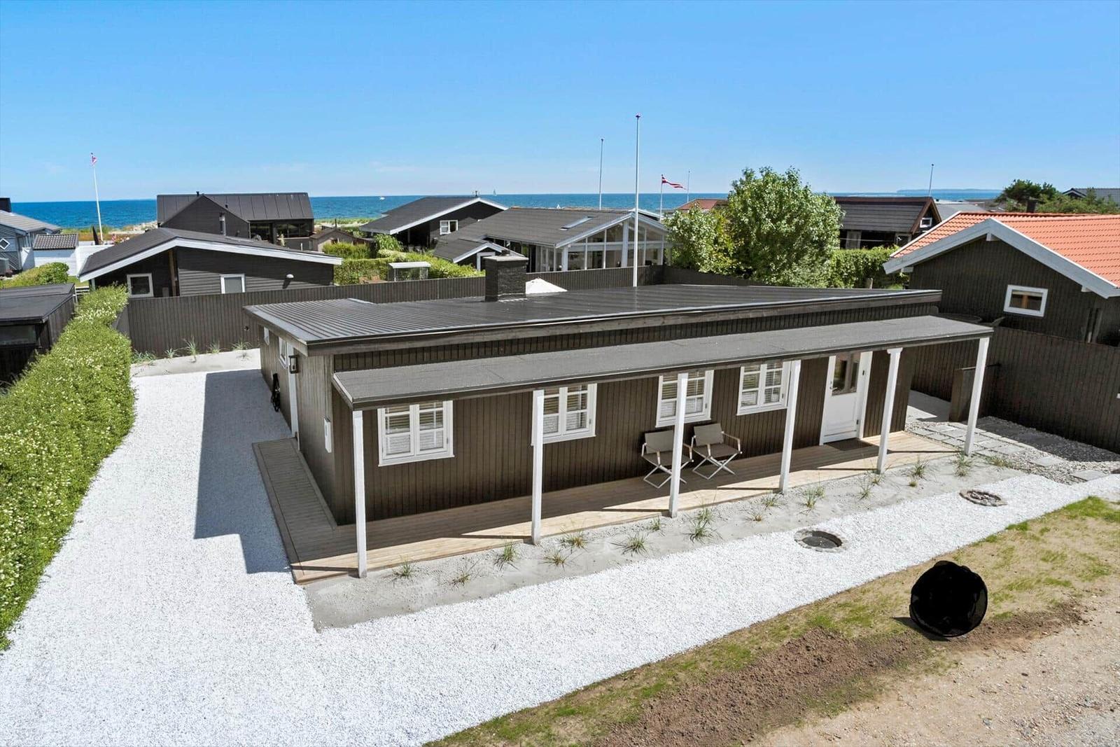 Moderne Ferienhaus mit Terrasse, Blick auf Meer und Nachbarhäuser.