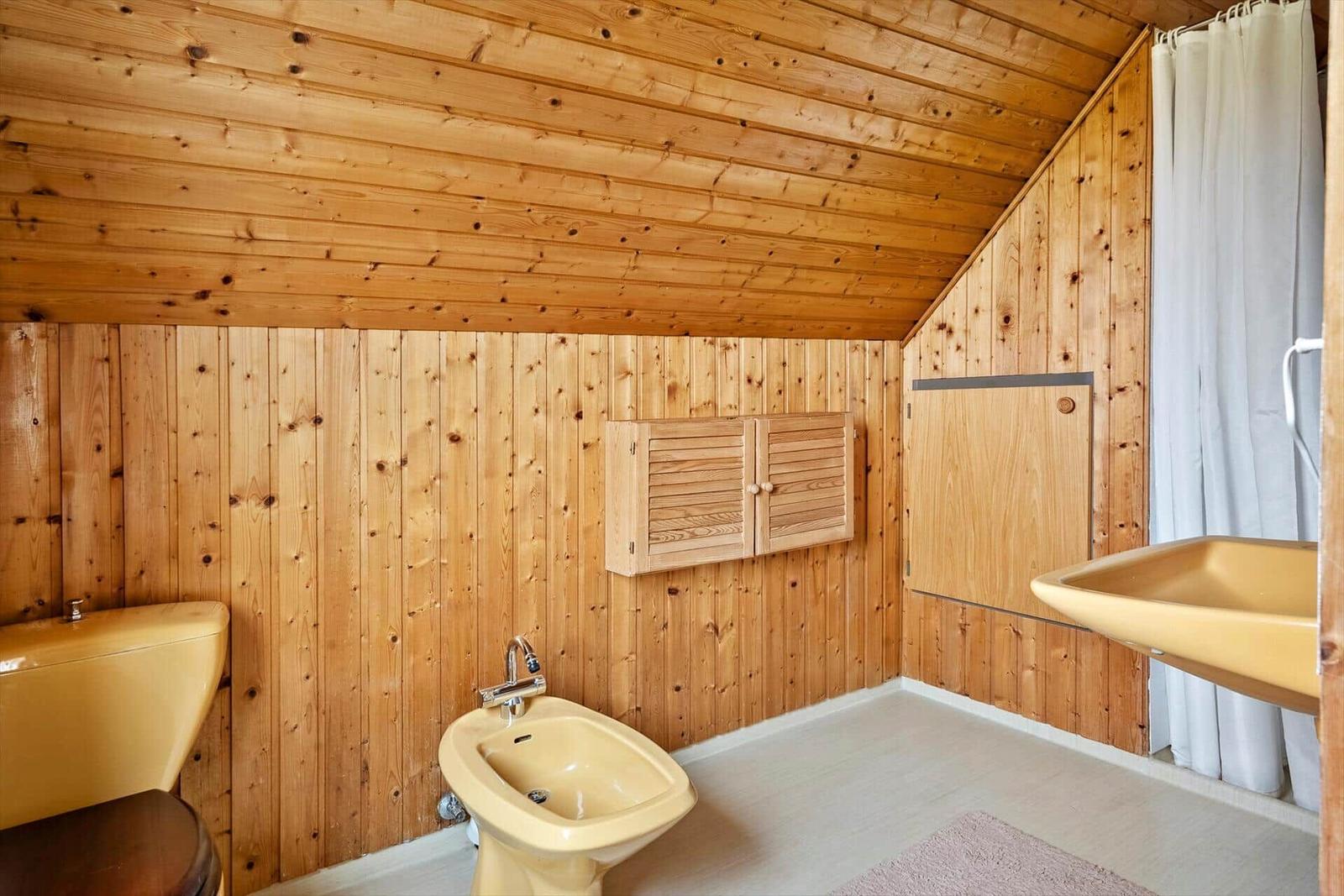 Bad mit Holzwand, Bidet, Waschbecken und Dusche