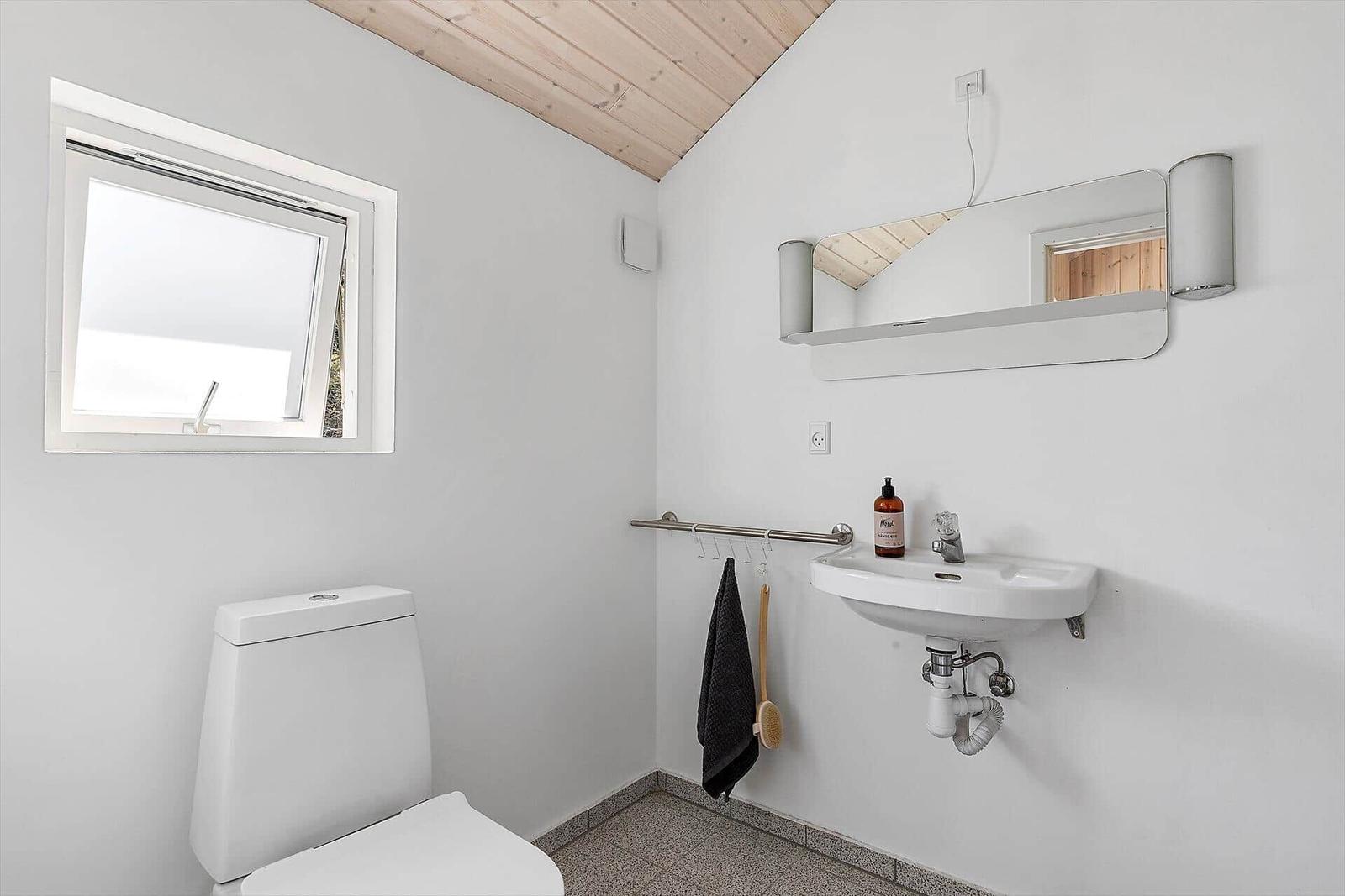 Badezimmer mit Toilette, Waschbecken und Dachfenster.