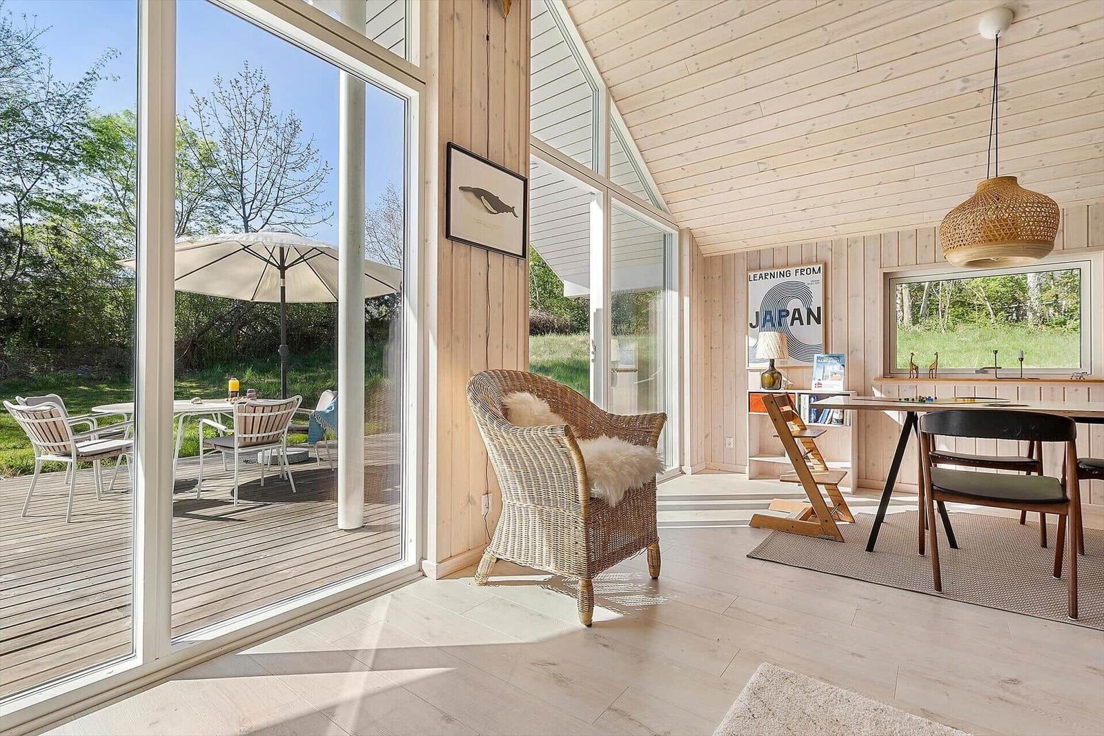 Wohnbereich mit Essbereich, Sitzgelegenheit und Blick auf die Terrasse mit Garten.