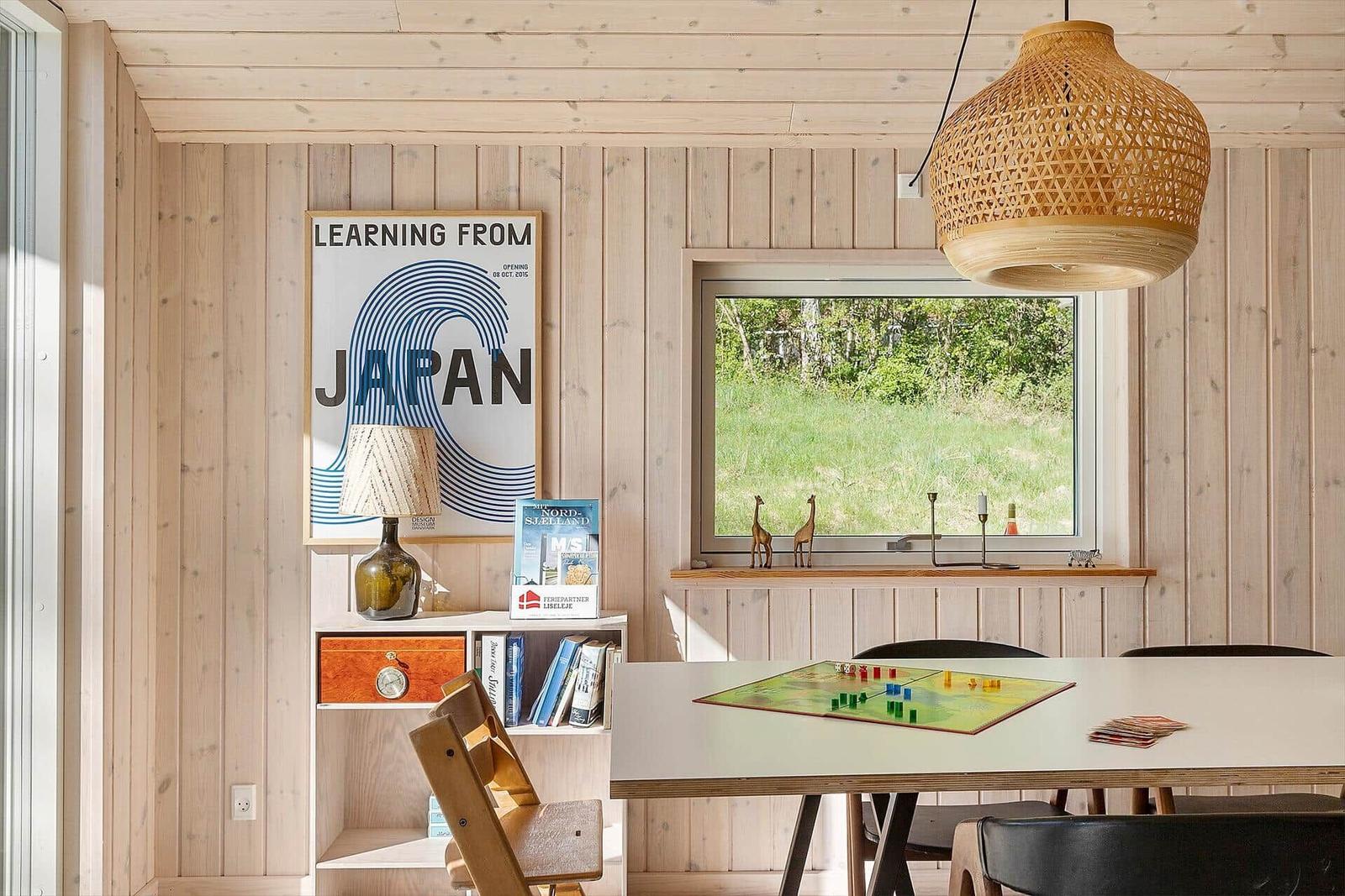 Essbereich mit Tisch, Stühlen und Fensterblick auf Grünland.