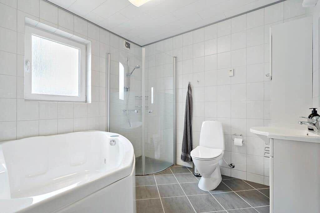 Badezimmer mit Badewanne, Dusche, Toilette und Waschbecken.