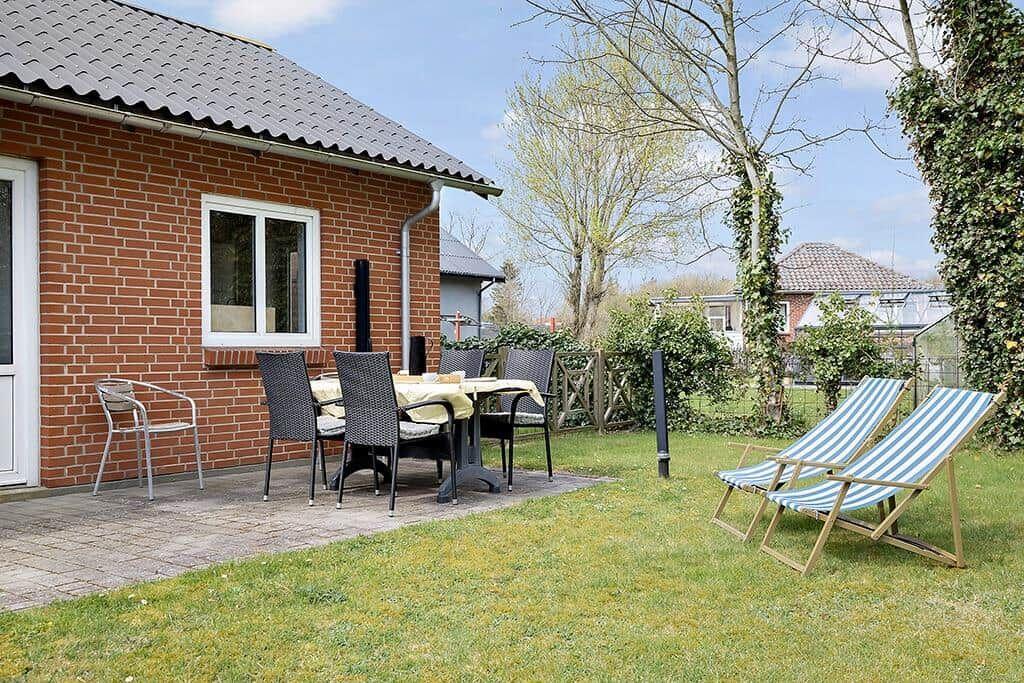 Terrasse mit Tisch, Stühlen und Liegestühlen im Garten