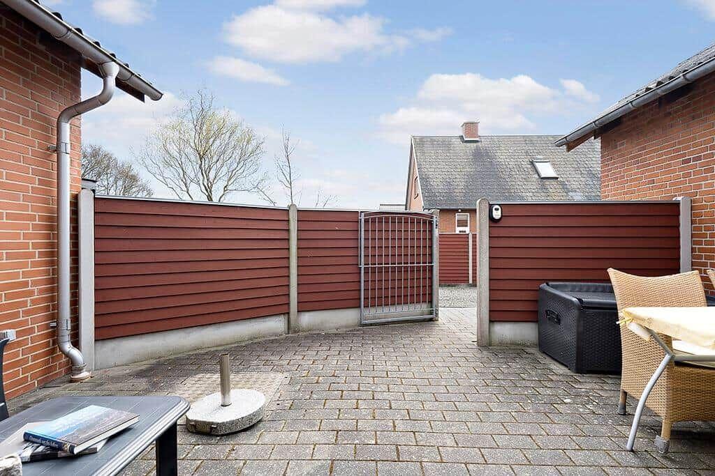 Hinterhof mit Terrasse, Holzgeländer und Gartentisch. Hinterhof mit Terrasse, Holzgeländer und Gartentisch.