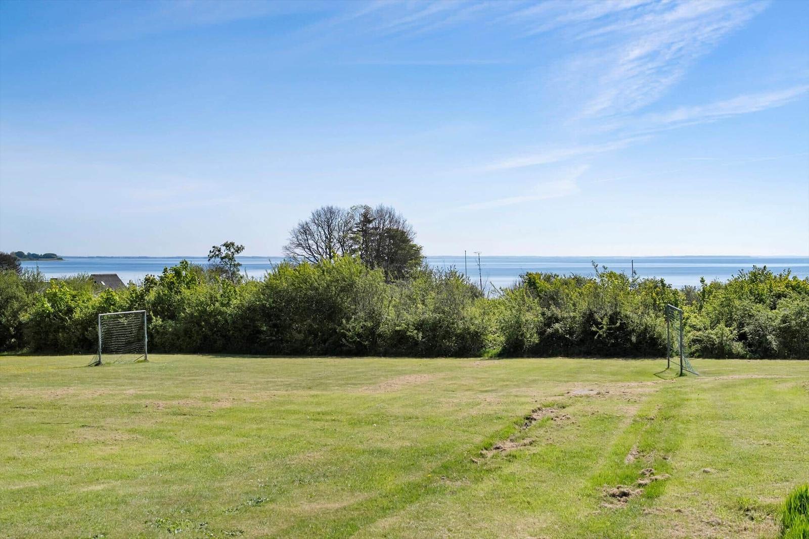 Green field with two goals and view of the water.
