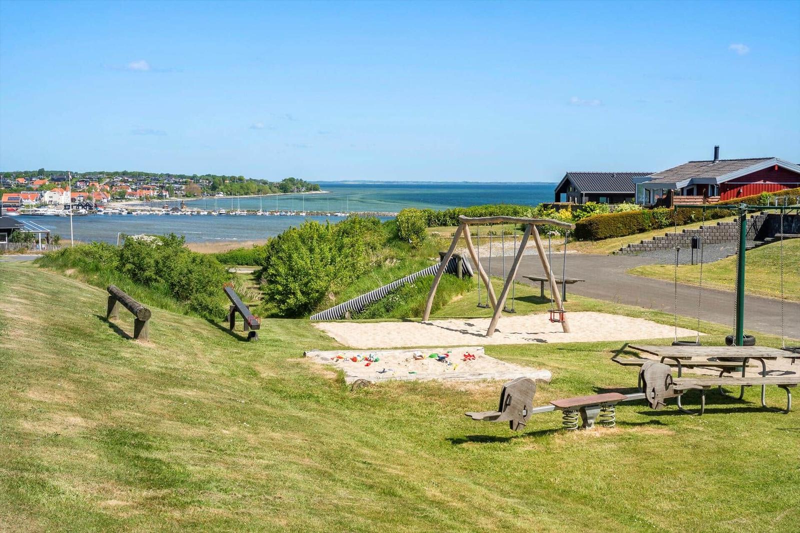 Playground with sandbox and swing by the lake