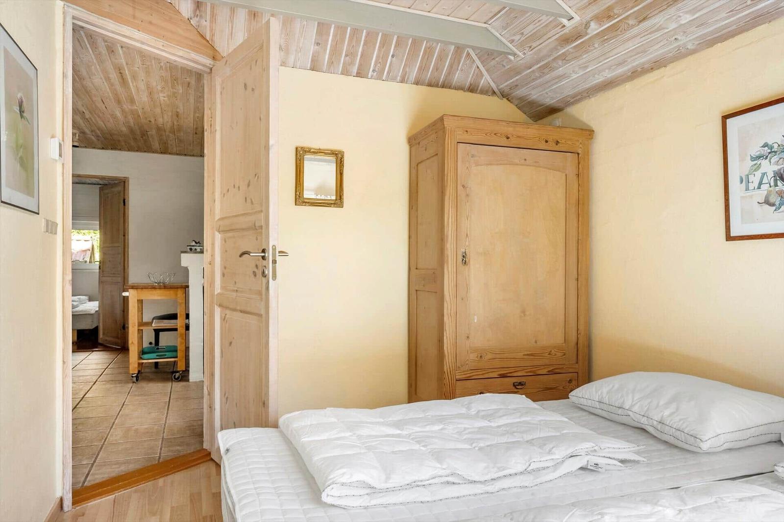 Bedroom with bed, wardrobe, and door to hallway.