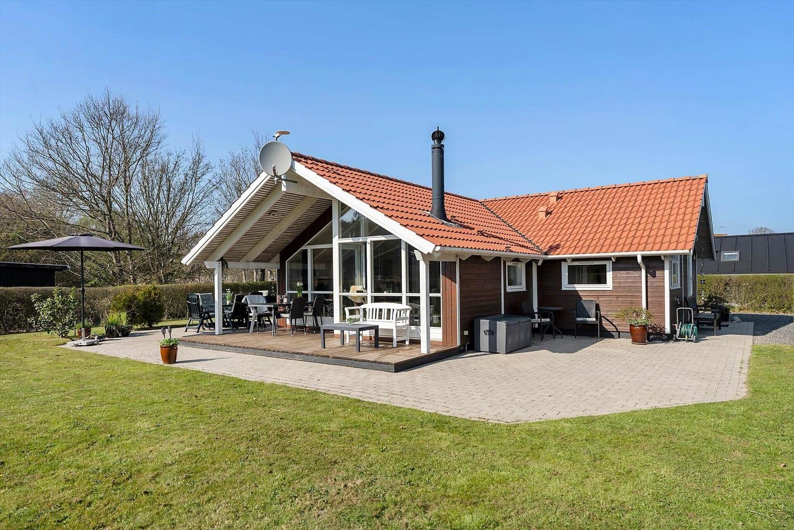 House with terrace, grill, and garden. Satellite dish and red roof tiles.