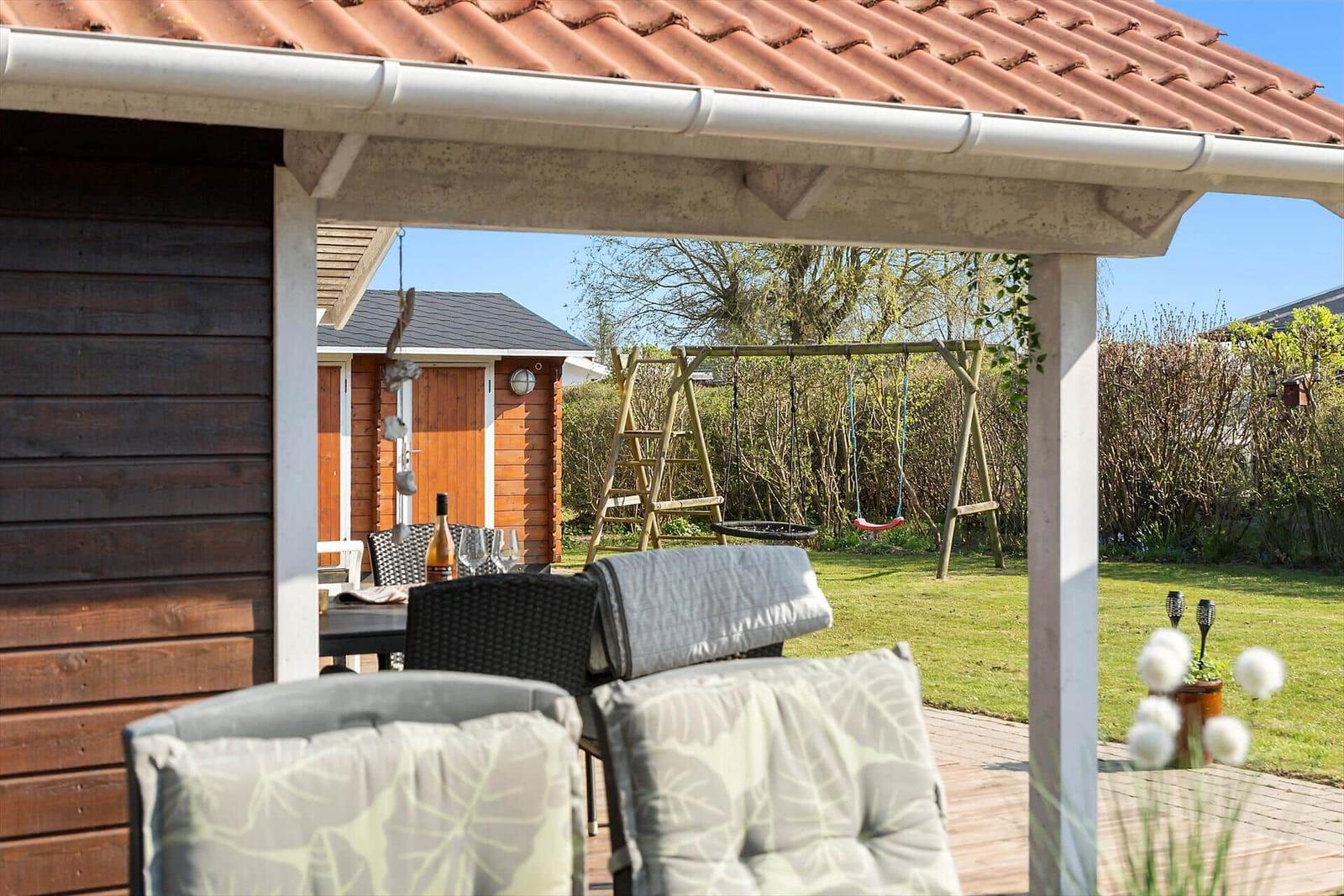 Patio with seating and view of the garden with swing.