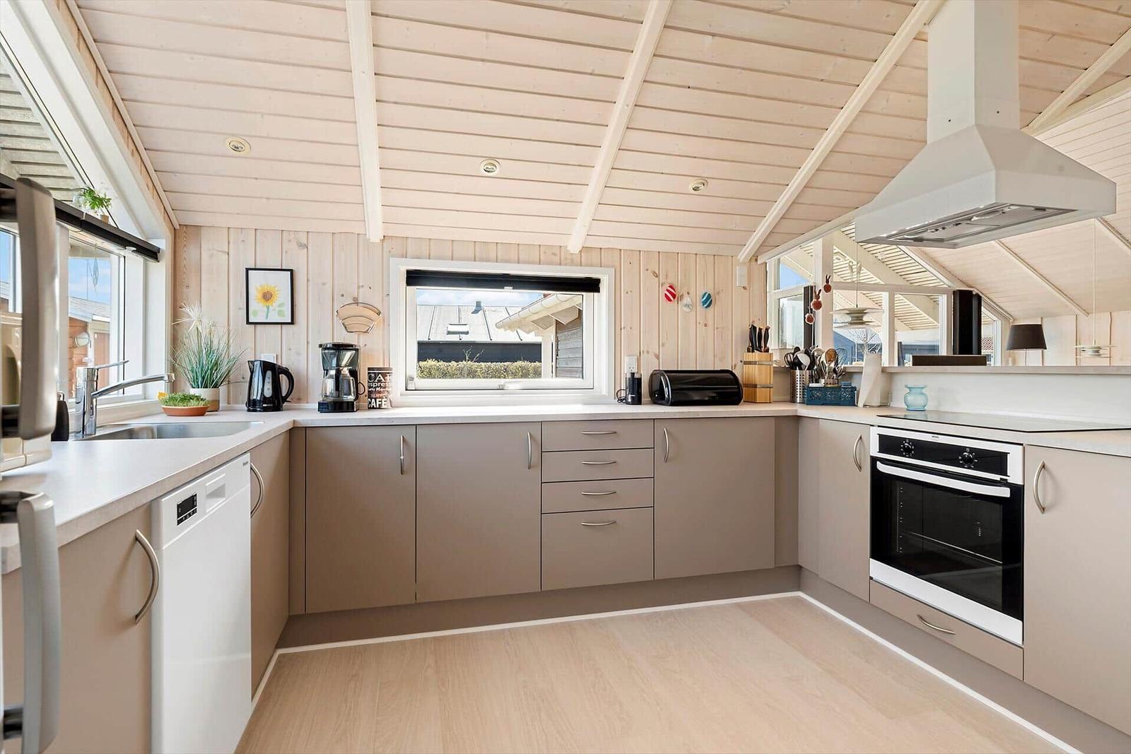 Kitchen with wooden ceiling, countertop, and appliances.
