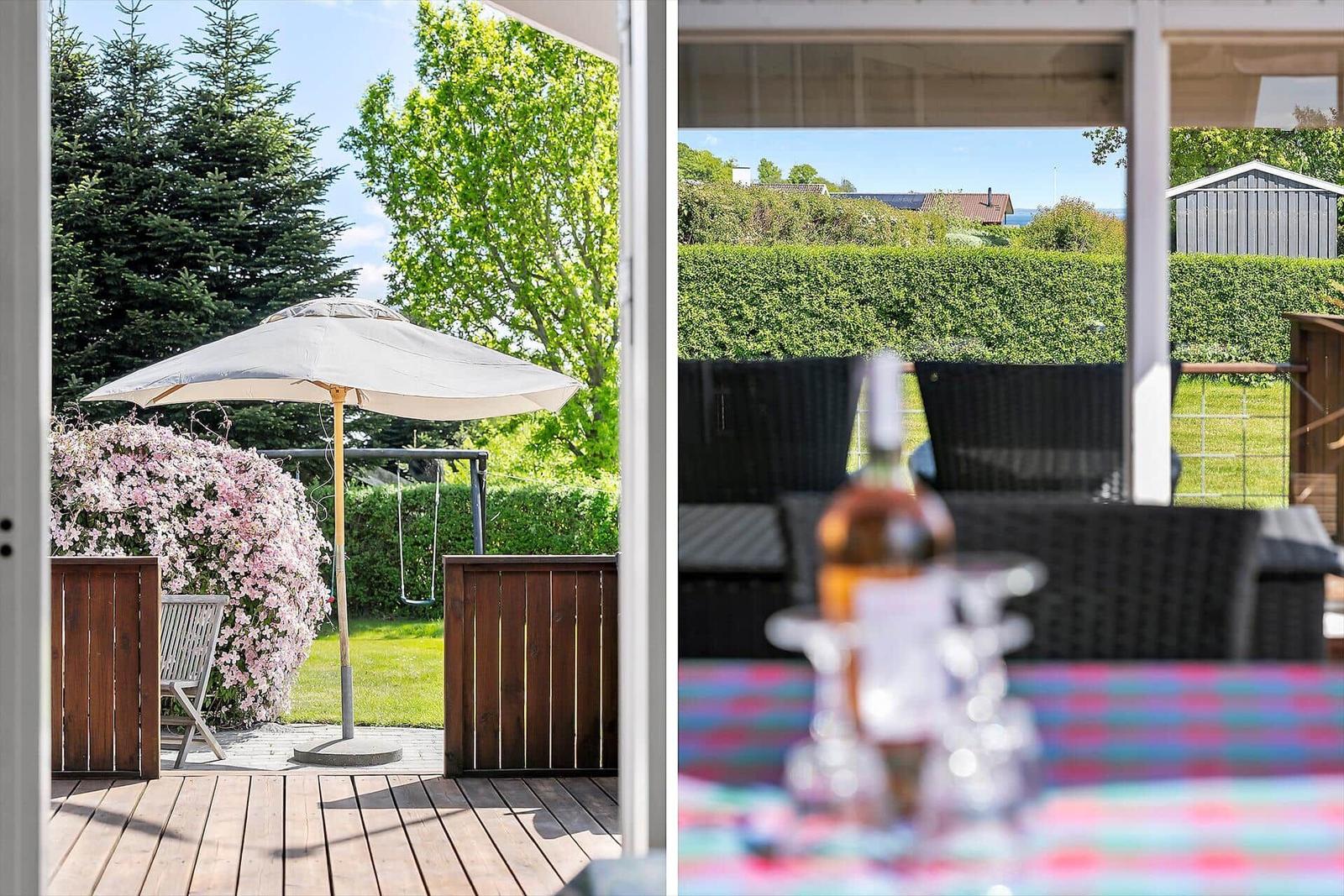 Terrasse mit Sonnenschirm, Garten und Blick auf die Landschaft.