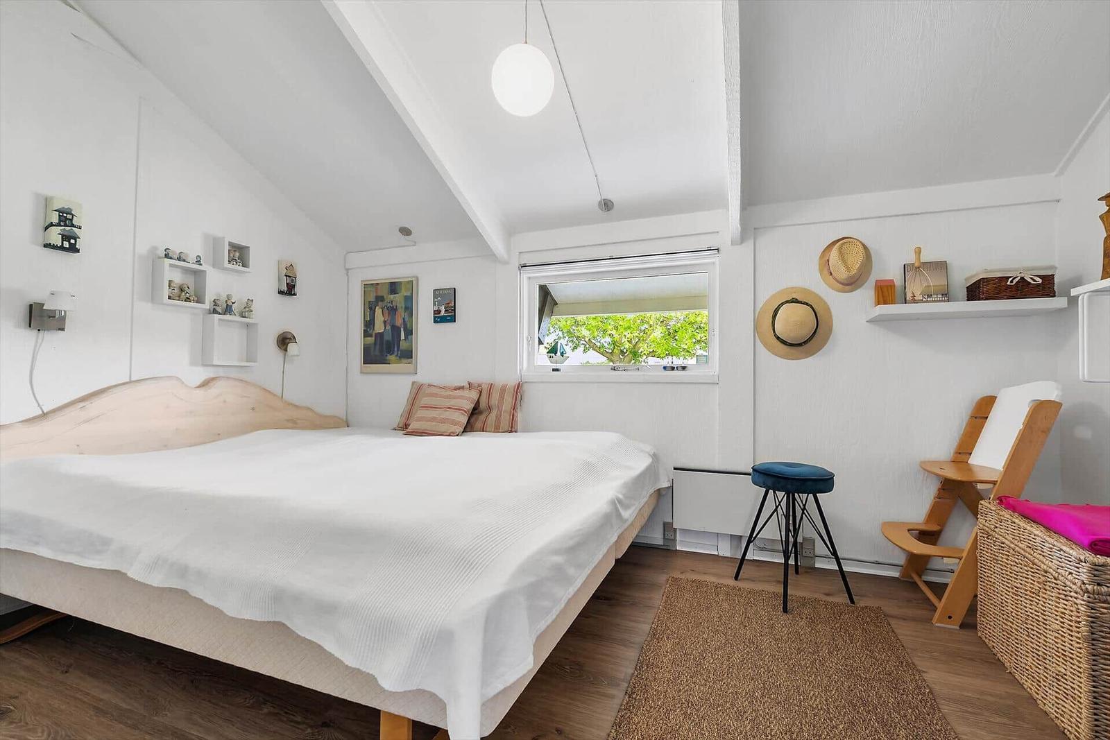 Schlafzimmer mit Bett, Fenster und Stuhl
