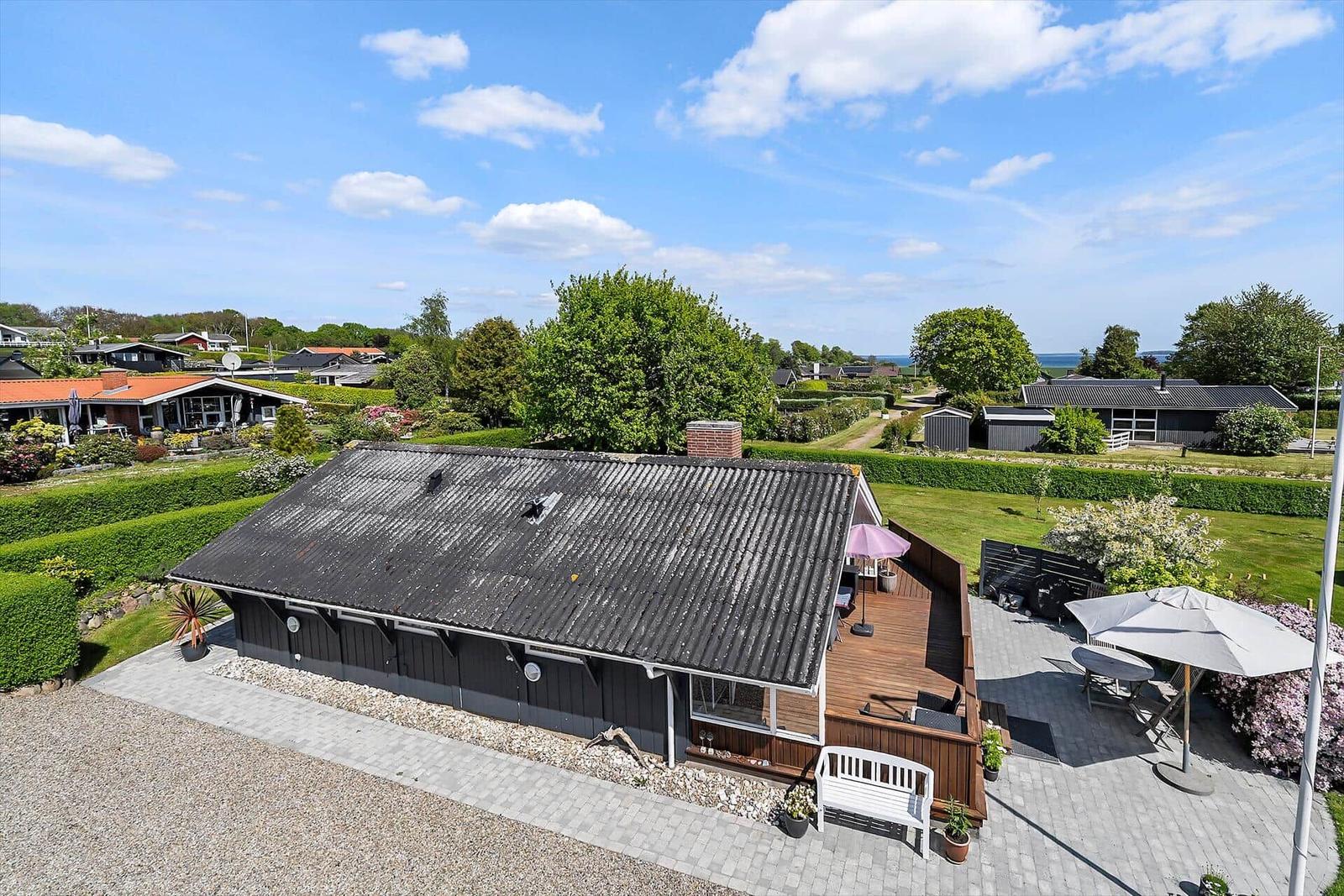 Haus mit Terrasse, Garten und Blick auf die Landschaft.