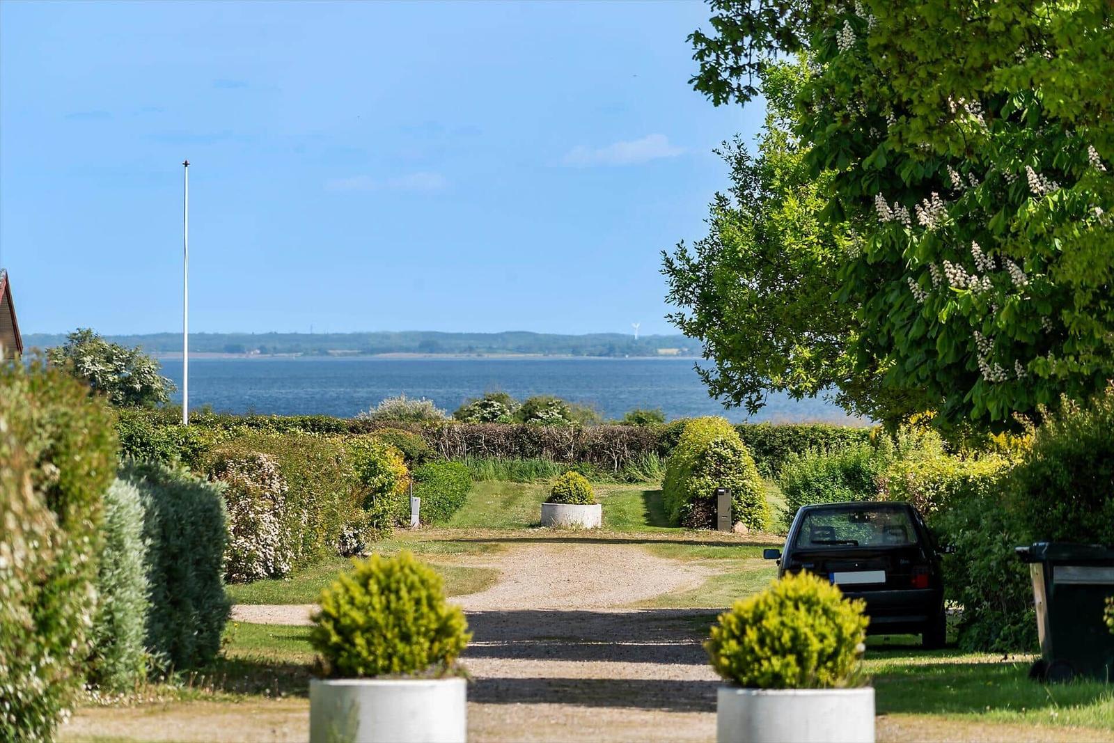 Einfahrt mit Grünflächen und Blick aufs Meer