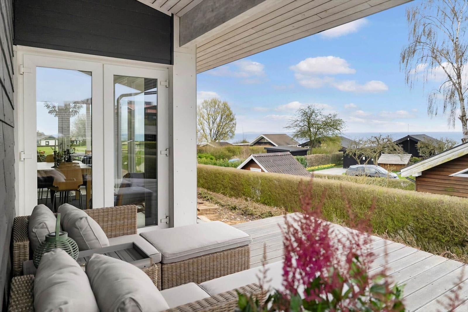 Deck with seating and view of fields and houses.