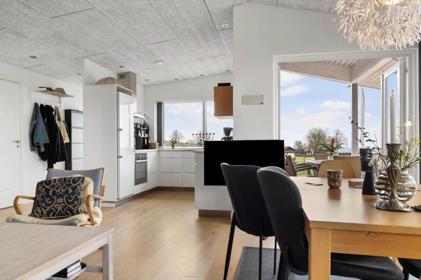 Kitchen, dining area, and living space with large window view.