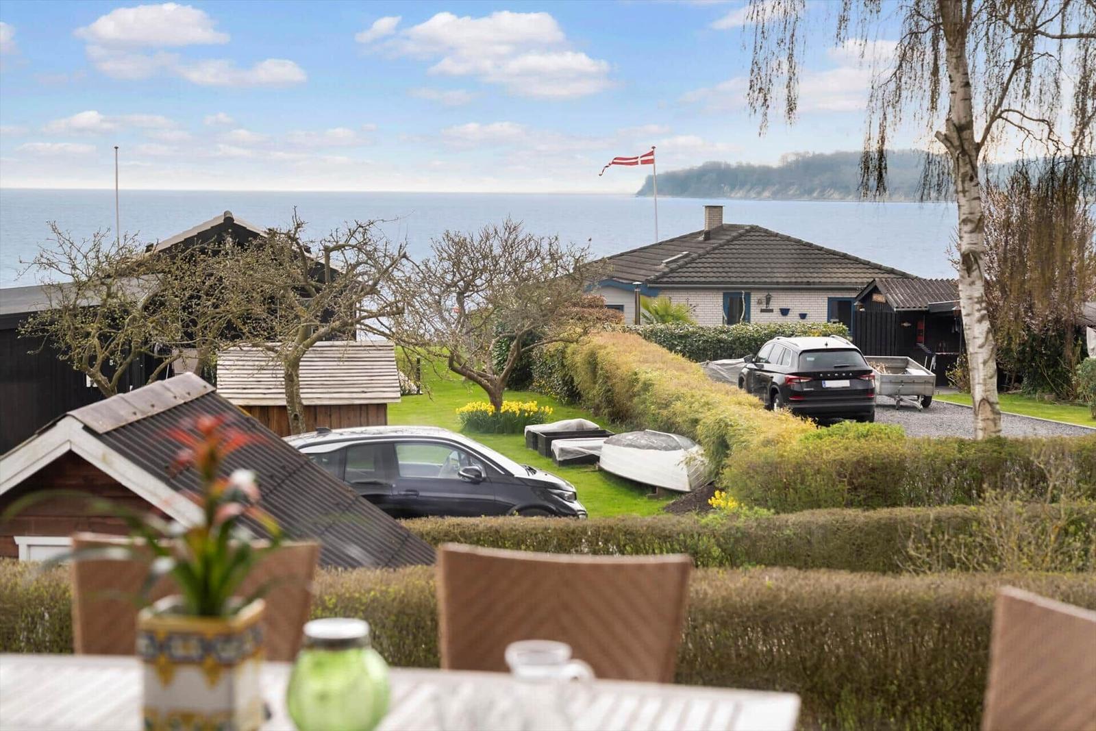 Sea view with garden, house, and boats. Flag waving in the wind.