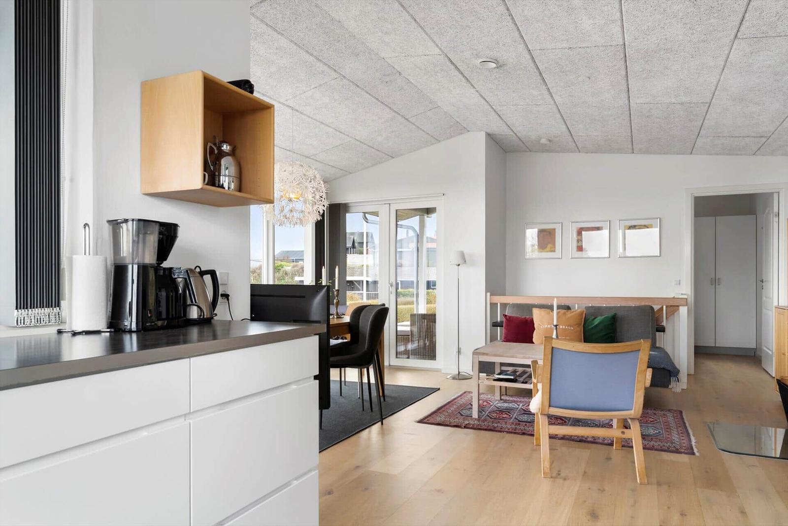 Kitchen with dining table, sofa, and armchair in the living area.