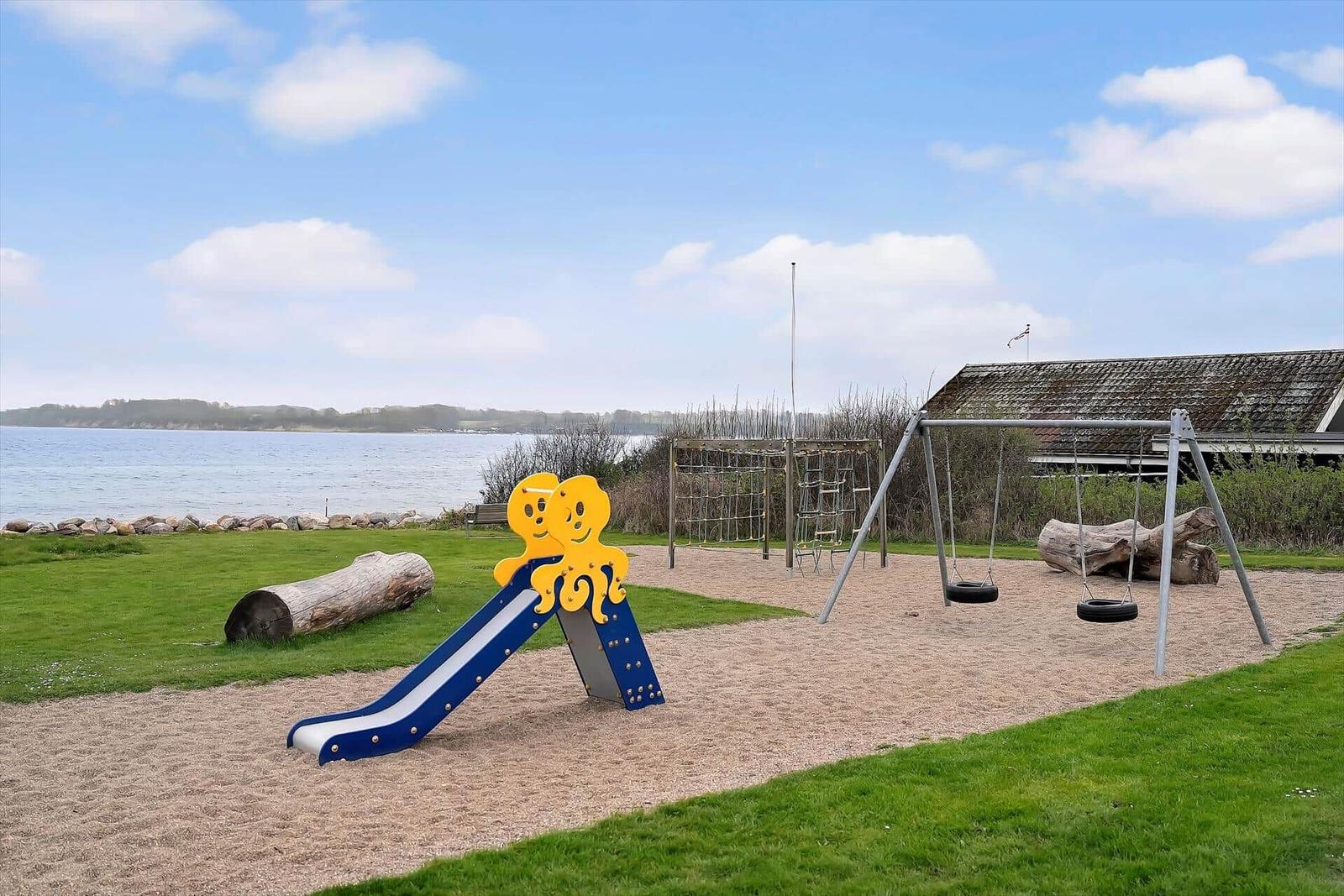 Playground with slide, swings, and climbing frame by the lake