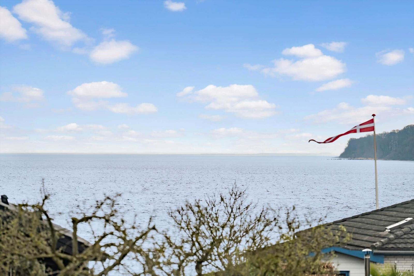 Sea view with Danish flag and cloudy sky