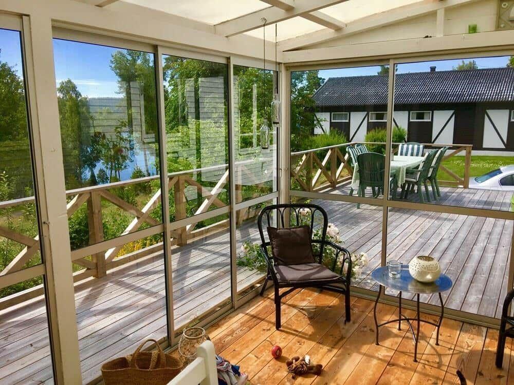 Terrasse mit Sitzgelegenheit und Blick auf See und Haus.