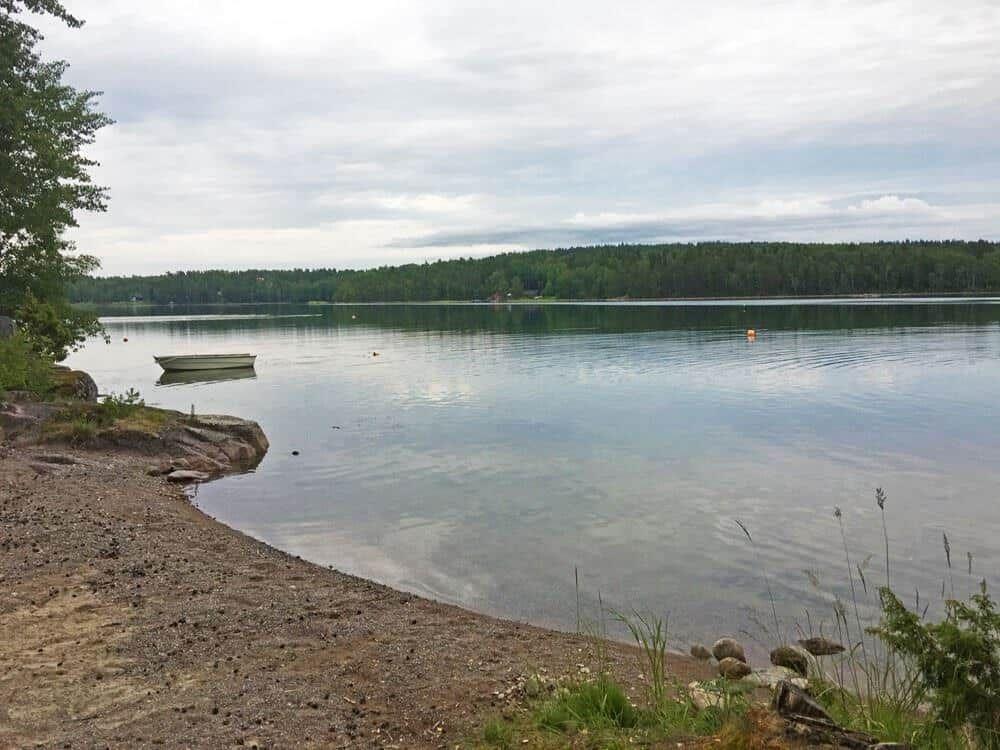 Ein ruhiger See mit kleinem Boot und grüner Umgebung.
