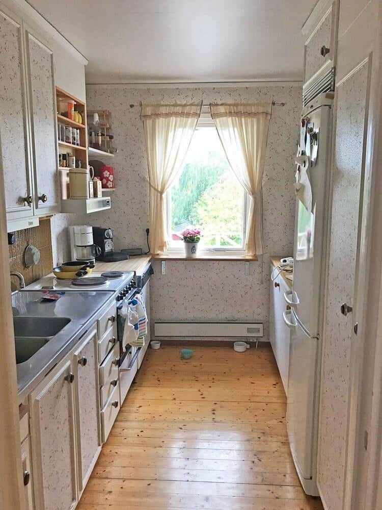 Küche mit Holzboden, Fenster und Küchengeräten