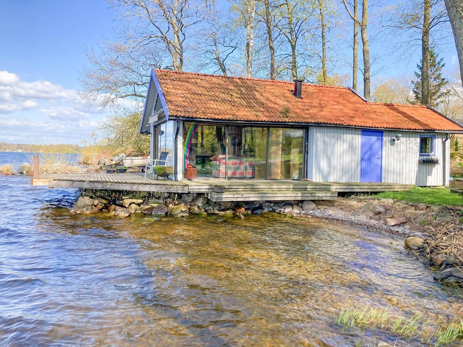 Haus am Wasser mit Terrasse und rotem Dach