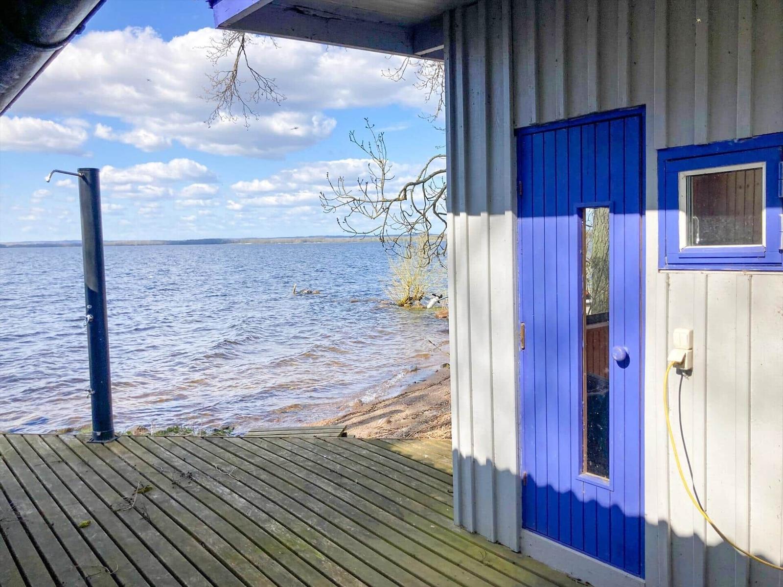Blauer Eingang mit Blick auf See und Holzterrasse