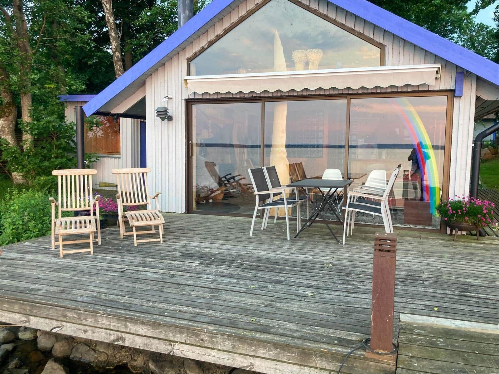 Terrasse mit Sitzgelegenheiten und Blick auf Wasser.