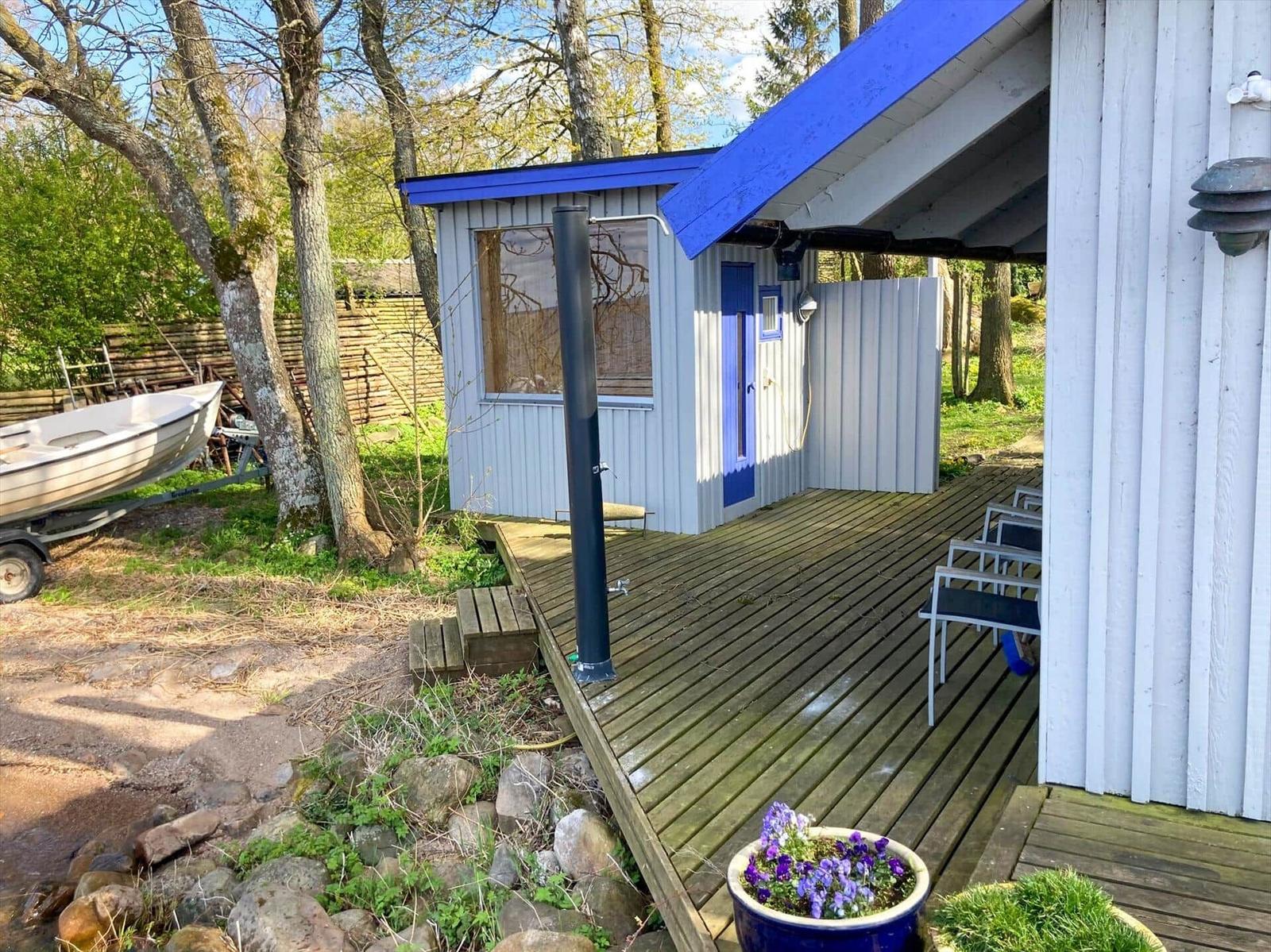 Holzterrasse mit blauem Pavillon und Boot auf Anhänger