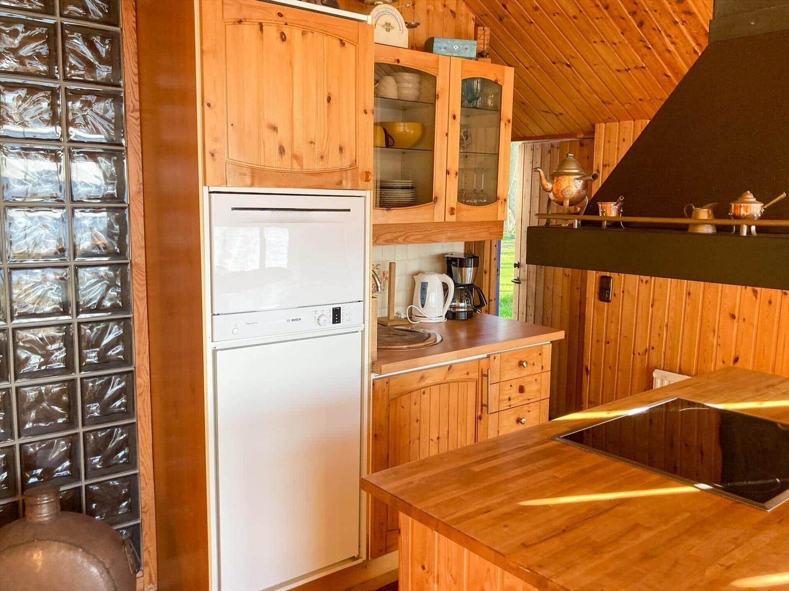 Küche mit Holzmöbeln, Spüle, Herd und Kühlschrank.