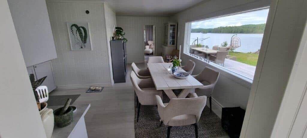 Esszimmer mit Tisch, Stühlen und Blick auf See