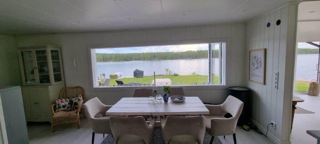 Esszimmer mit Tisch, Stühlen und Blick auf See