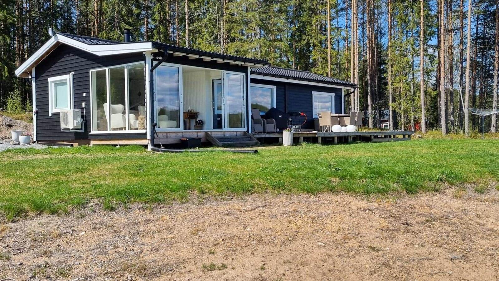 Schwarzes Haus mit Terrasse und Garten im Wald