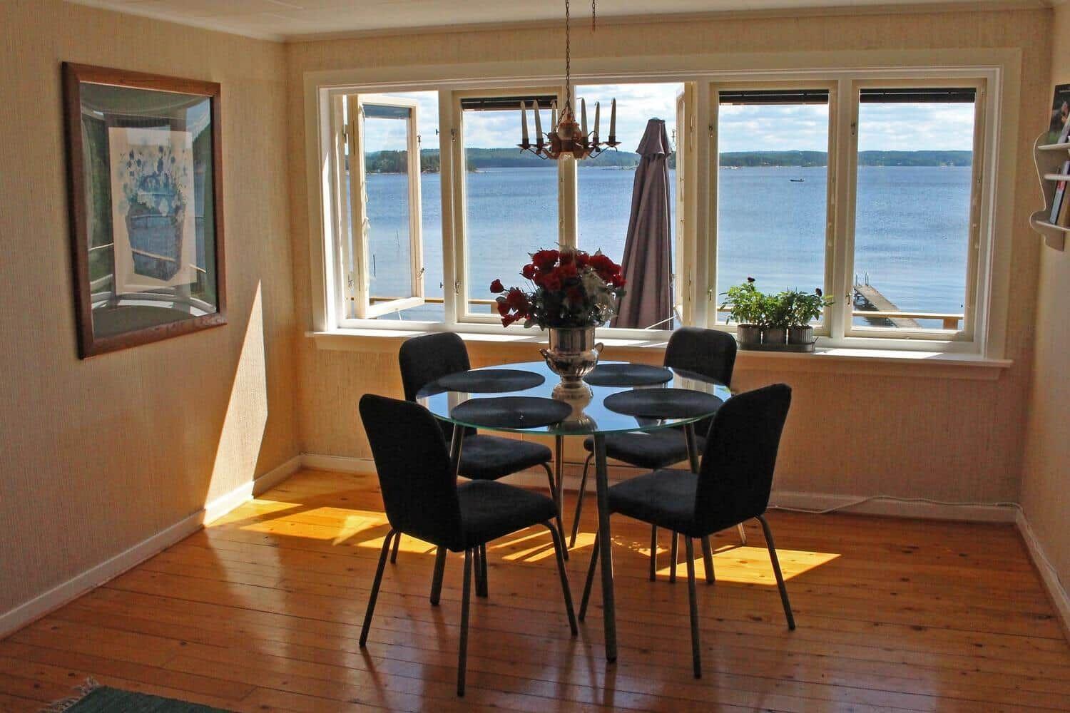 Esszimmer mit Tisch, Stühlen und Aussicht auf See