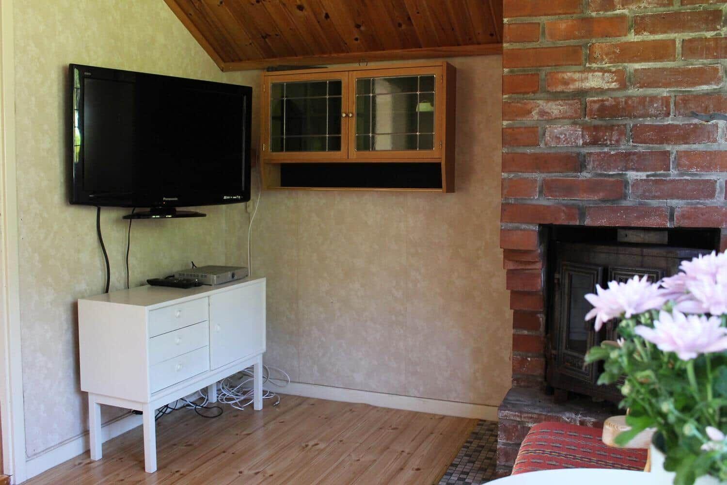 Wohnzimmer mit Kamin, Fernseher und Schrank