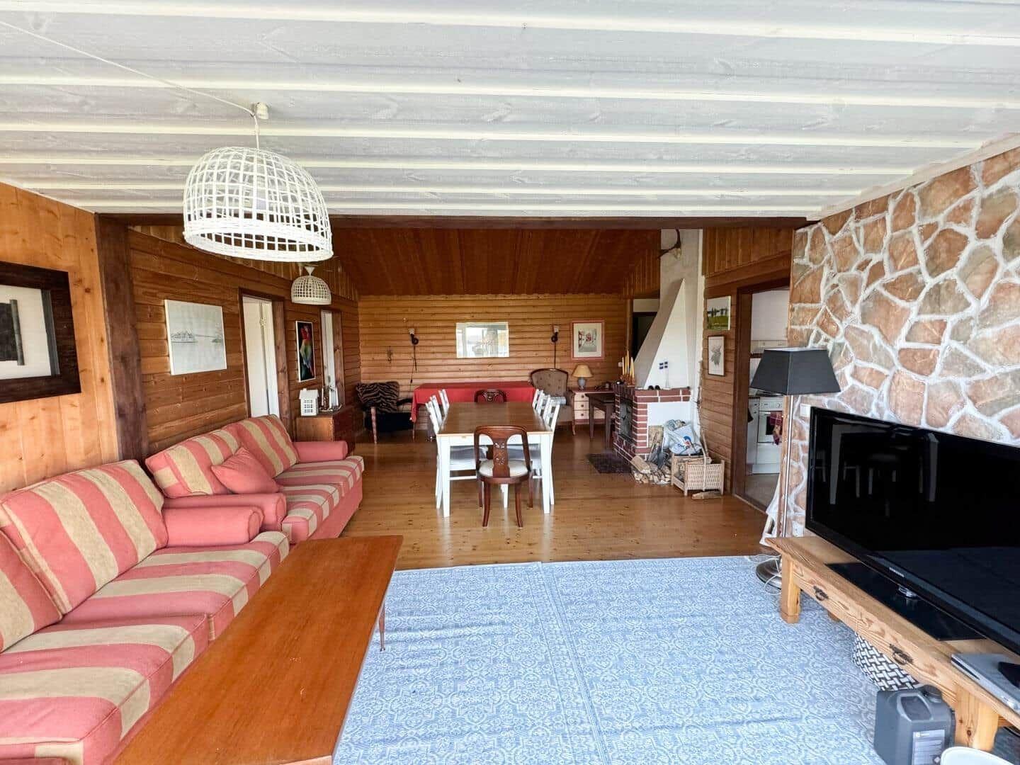 Wohnzimmer mit Sofa, Esstisch und Kaminwand