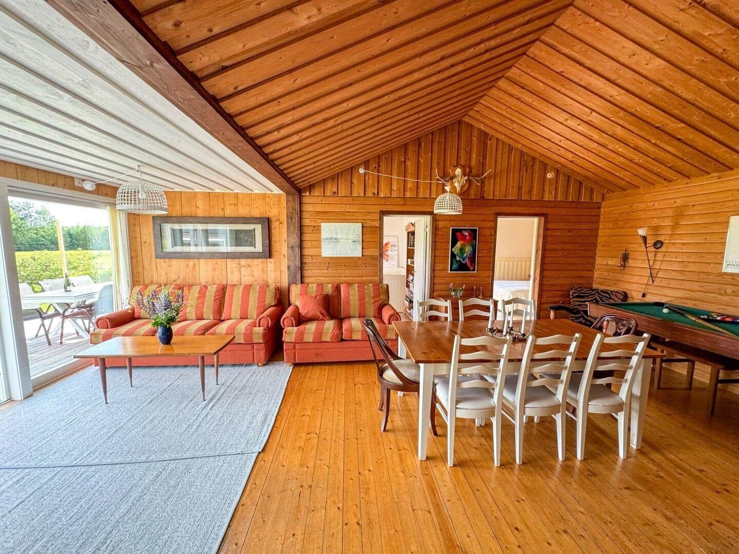 Wohnzimmer mit Essbereich und Billardtisch in Holzhaus