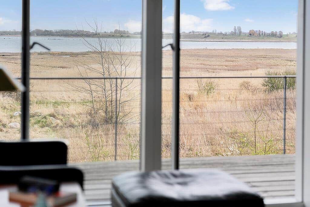 Durch das Fenster ist ein Fluss und eine trockene Uferlandschaft zu sehen.