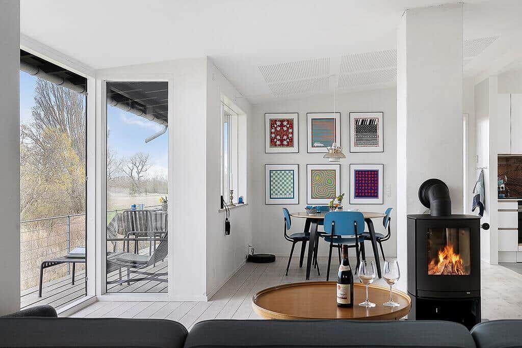 Essbereich mit Tisch, Stühlen und Kamin. Durchgang zur Terrasse mit Sitzgelegenheiten.