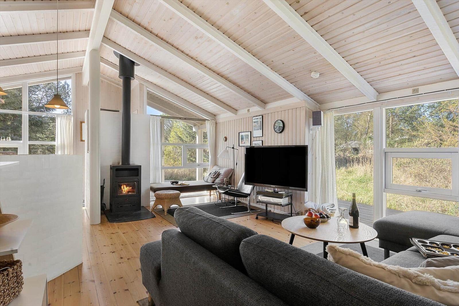 Wohnzimmer mit Kamin, TV und großem Fensterblick
