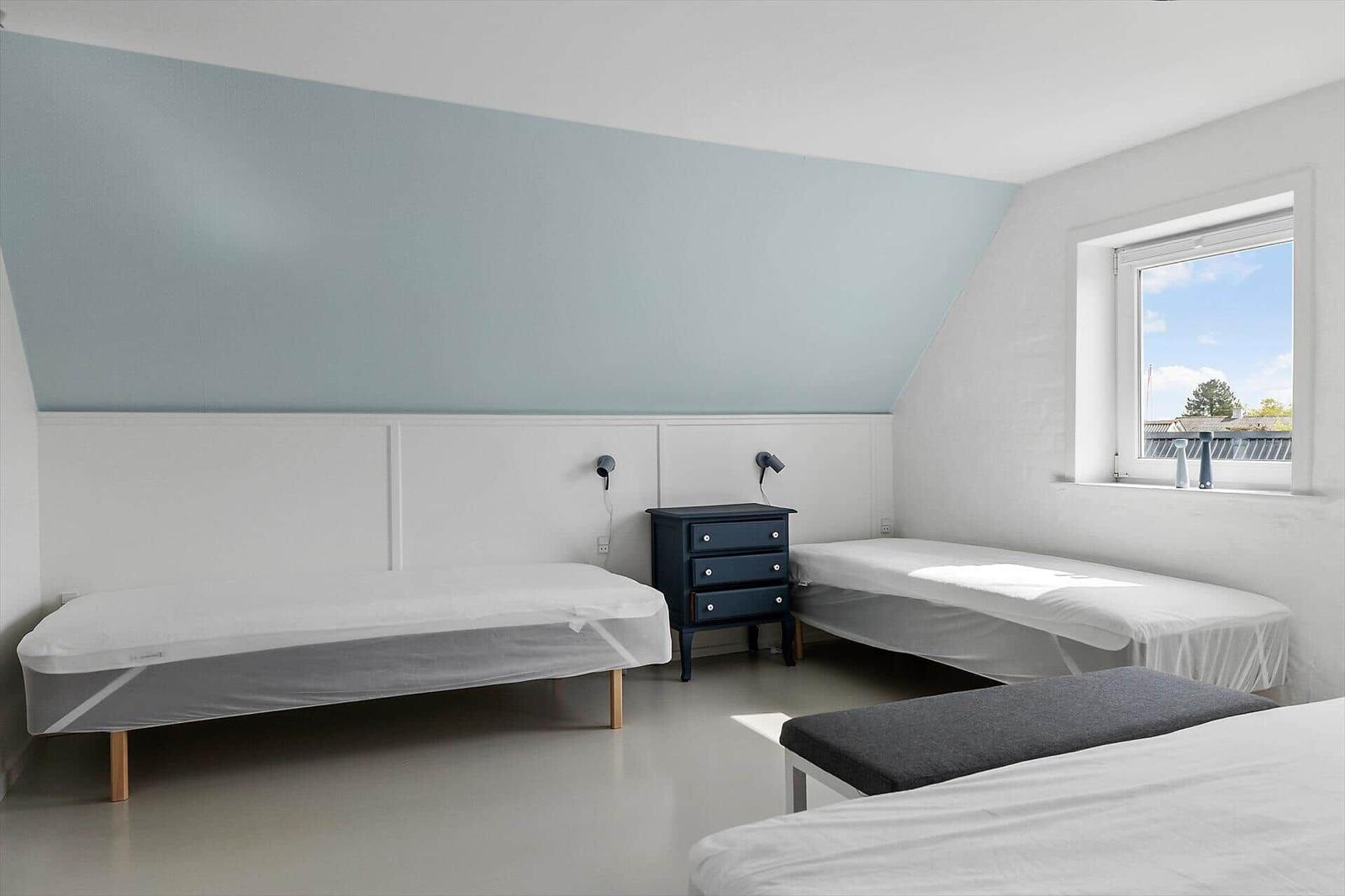 Zimmer mit zwei Betten, Nachttisch und Fenster mit Blick.