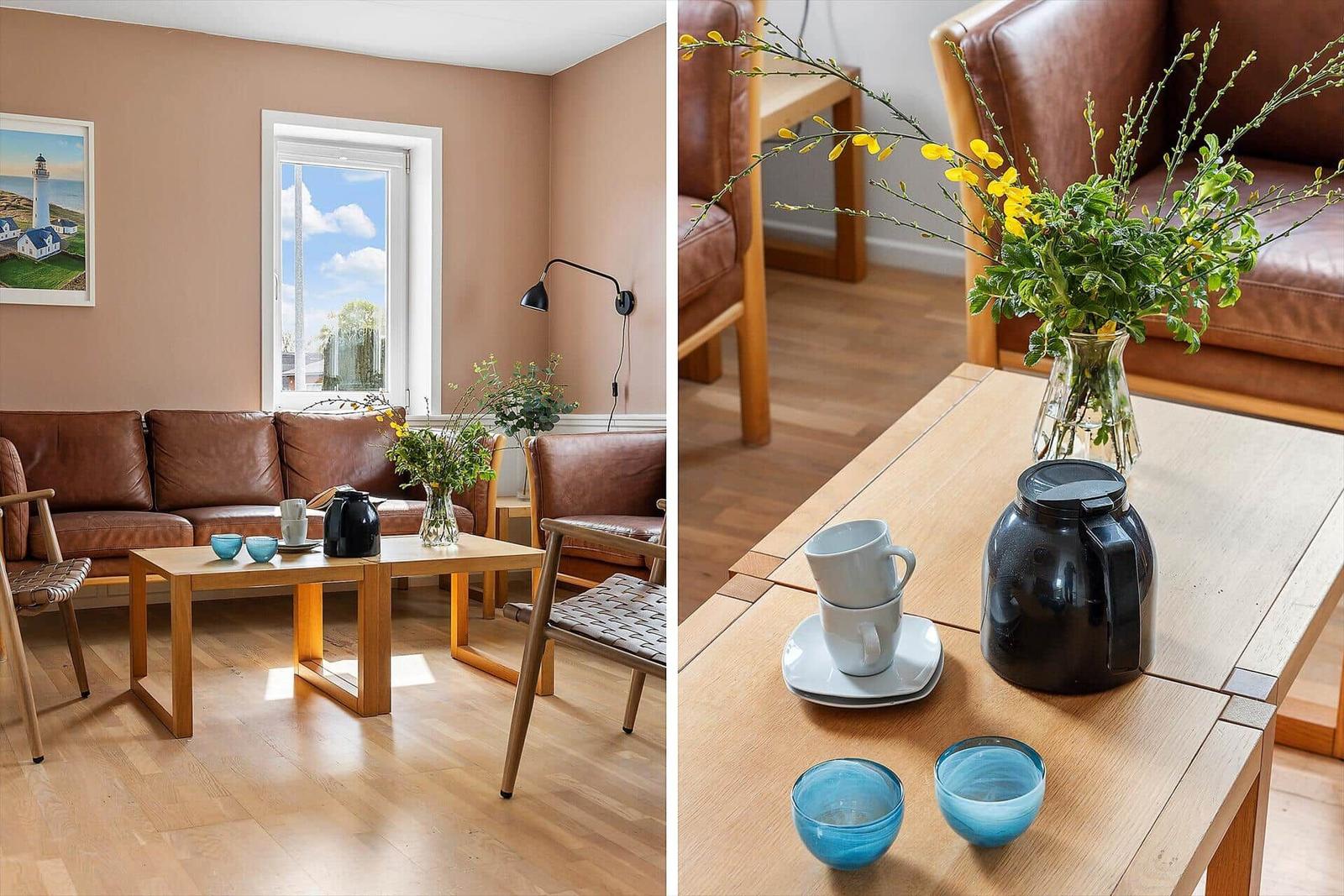 Wohnzimmer mit braunem Ledersofa, Holztisch und Fenster mit Blick.