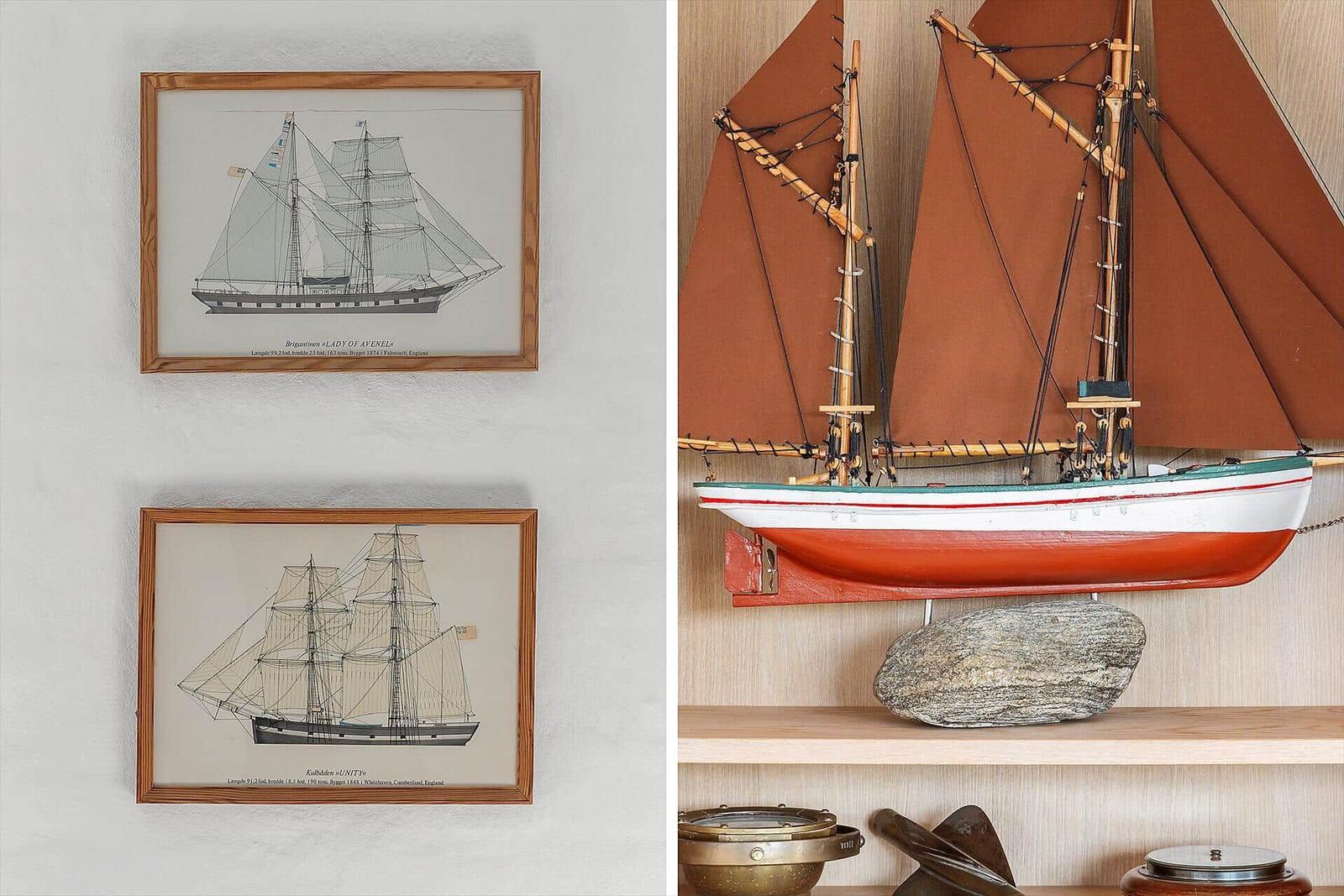 Zwei gerahmte Segelschiffzeichnungen und ein hölzernes Segelschiffmodell auf einem Regal.