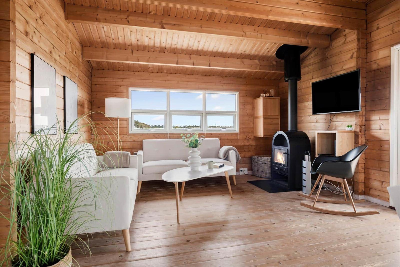 Living room with wood walls, sofa, fireplace, and TV.