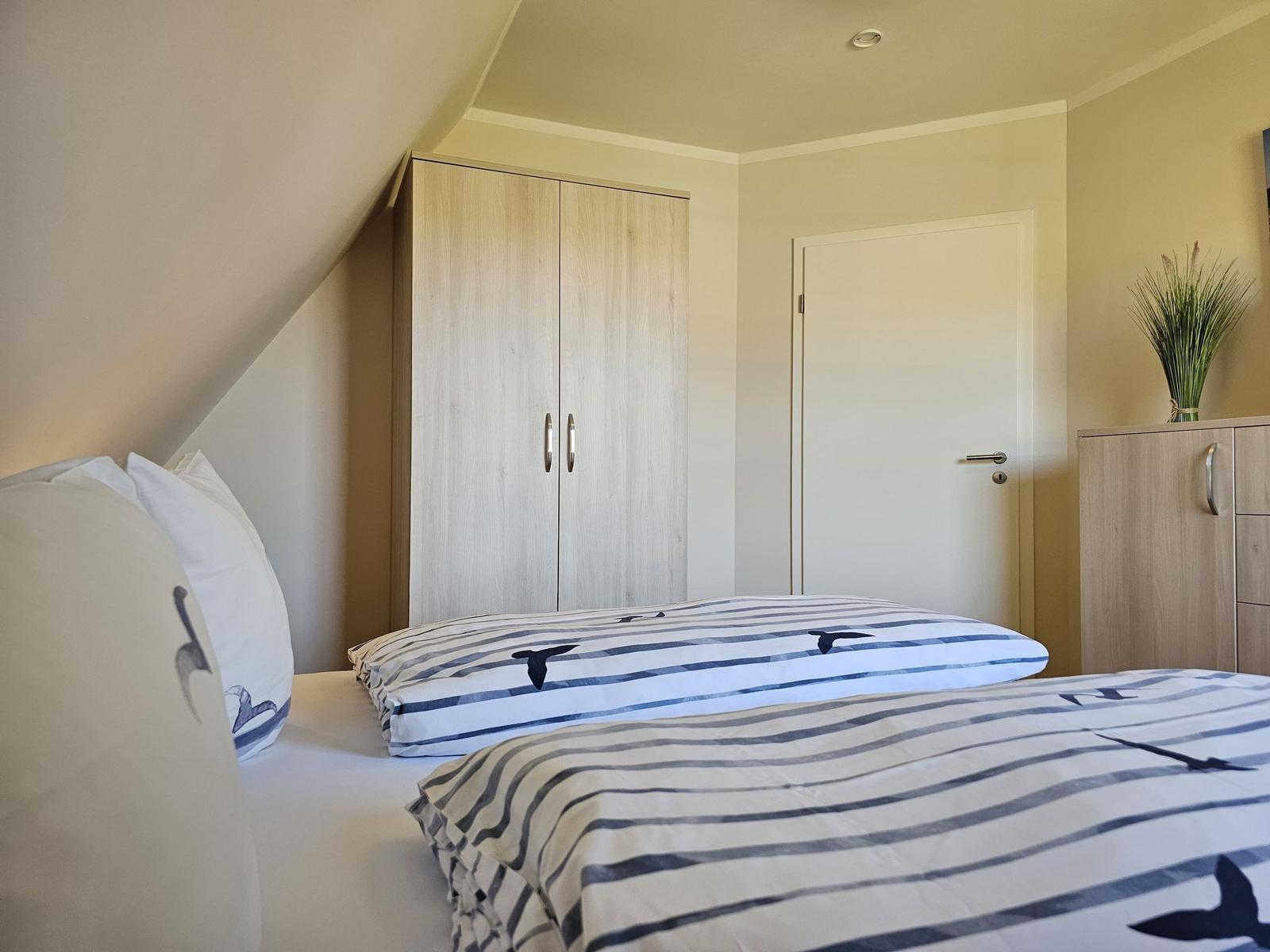 Schlafzimmer mit Doppelbett, Kleiderschrank und Tür