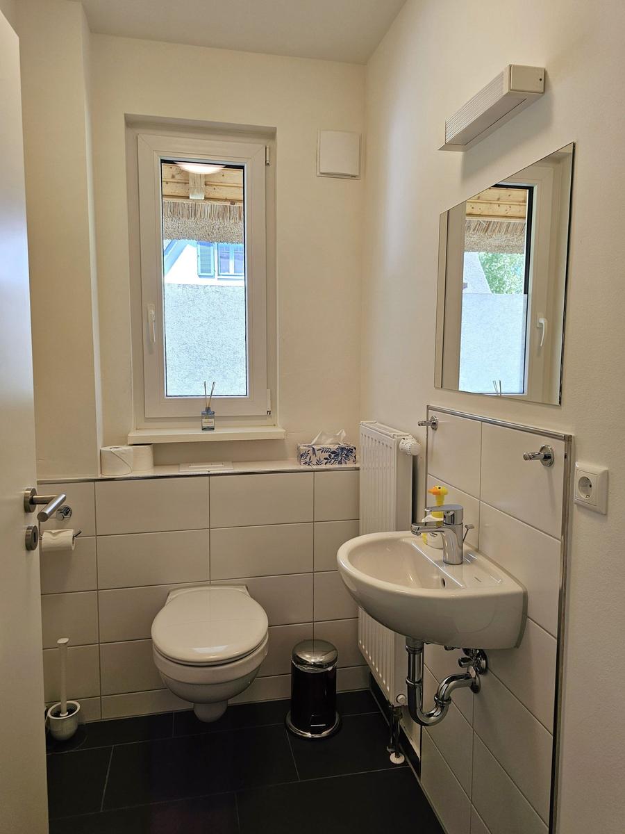 Badezimmer mit Toilette, Waschbecken und Fenster