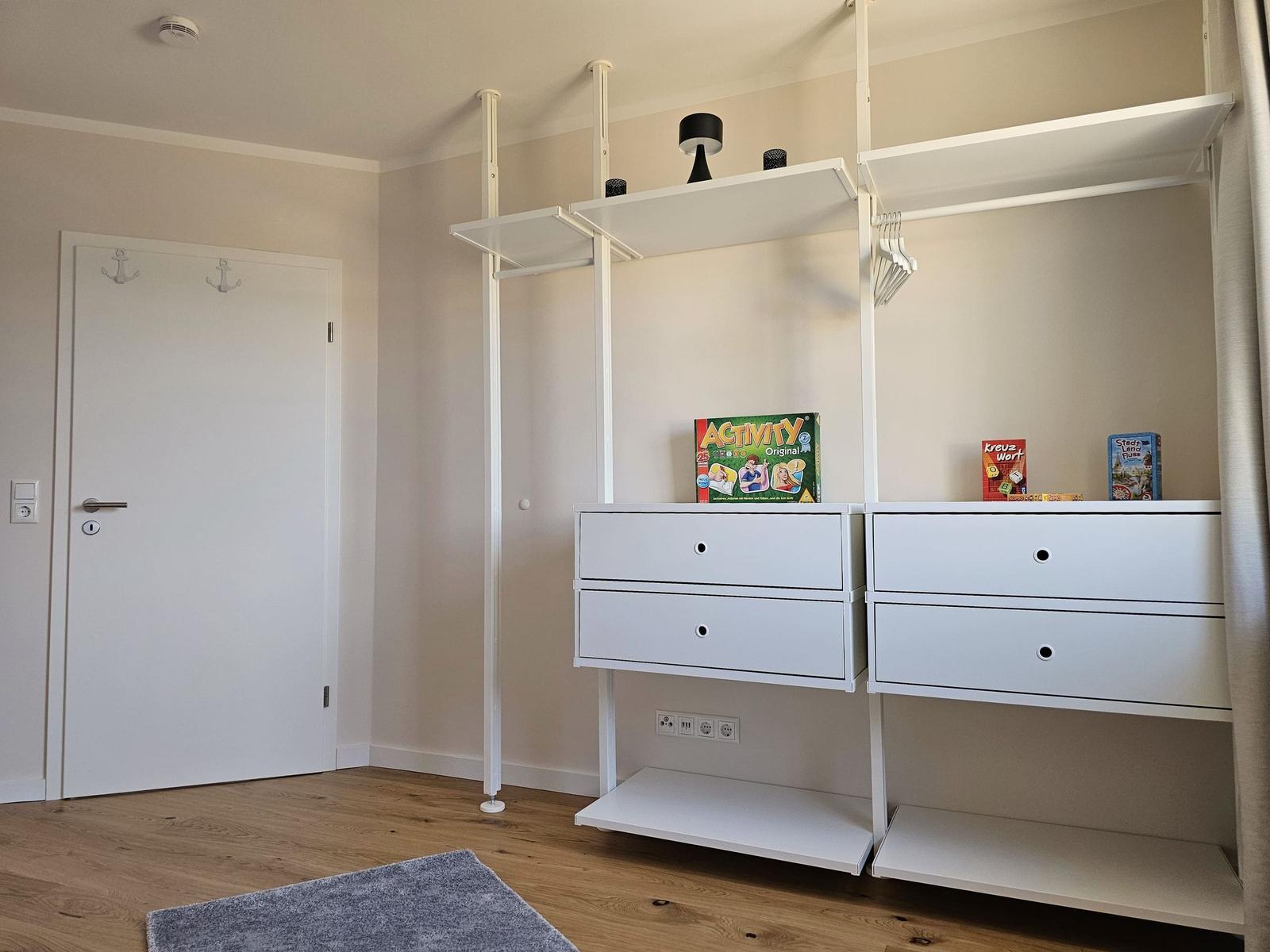 Schlafzimmer mit weißen Schränken und Spielzeug